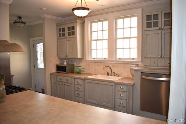 kitchen featuring stainless steel appliances, light countertops, a sink, and decorative backsplash