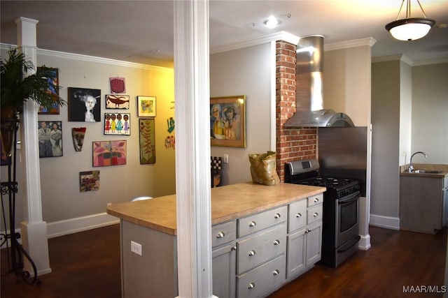 kitchen featuring wall chimney exhaust hood, dark wood finished floors, stainless steel range with gas stovetop, and crown molding