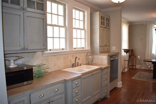 kitchen with dishwashing machine, a sink, ornamental molding, decorative backsplash, and stainless steel microwave