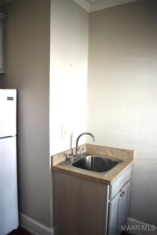 kitchen featuring light countertops, a sink, and freestanding refrigerator