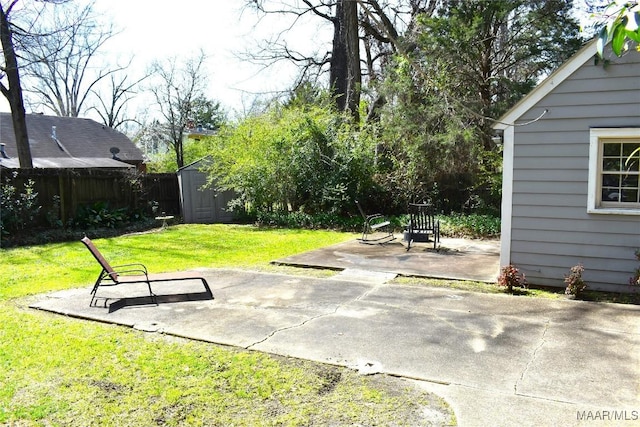 exterior space with an outbuilding, a patio area, fence, and a shed