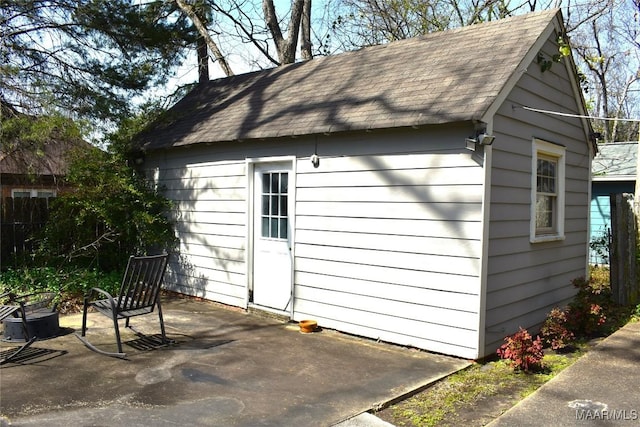 view of outbuilding featuring fence and an outbuilding