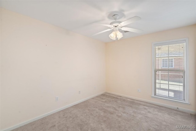 spare room with ceiling fan, carpet flooring, and baseboards