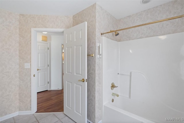 bathroom featuring tile patterned flooring, shower / bath combination, and wallpapered walls