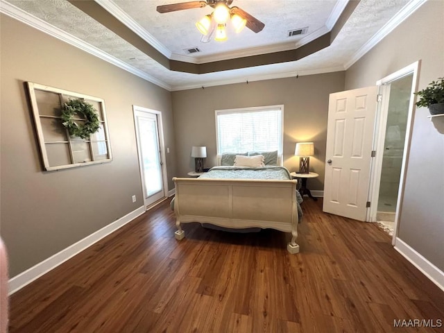 bedroom with a raised ceiling, visible vents, and dark wood finished floors