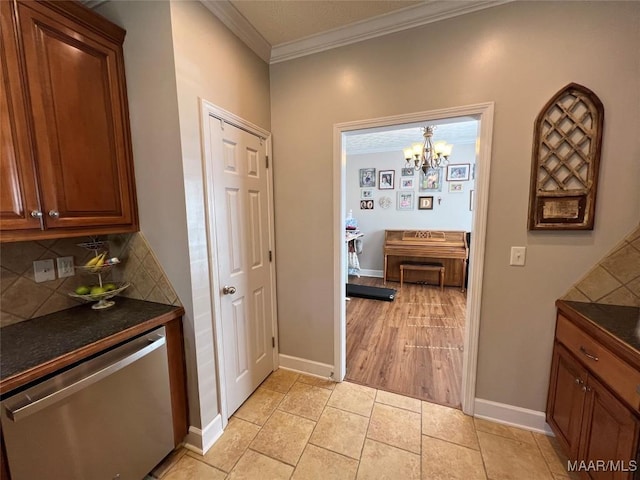 hall featuring light tile patterned floors, baseboards, and crown molding