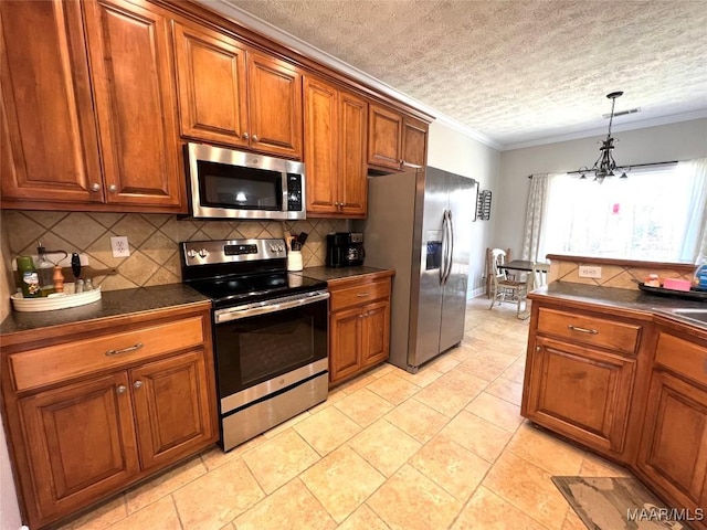 kitchen featuring dark countertops, brown cabinets, stainless steel appliances, and crown molding