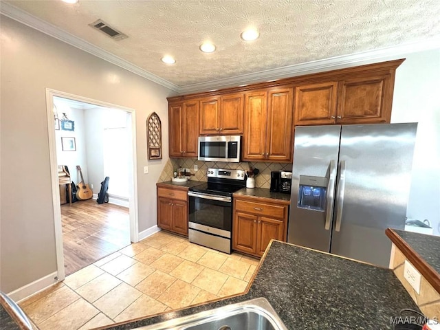 kitchen with stainless steel appliances, visible vents, brown cabinets, tasteful backsplash, and crown molding