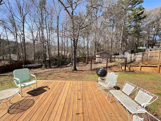 wooden terrace with a yard, a fenced backyard, and an outdoor structure