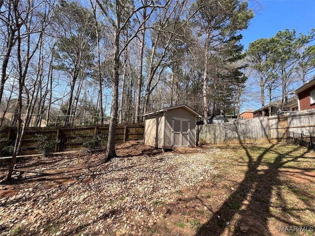 view of yard featuring a storage shed, a fenced backyard, and an outdoor structure