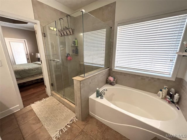 ensuite bathroom with a stall shower, a wealth of natural light, connected bathroom, tile patterned flooring, and a bath