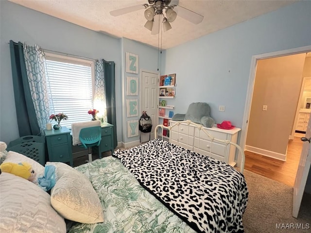 bedroom with ceiling fan, baseboards, a textured ceiling, and wood finished floors