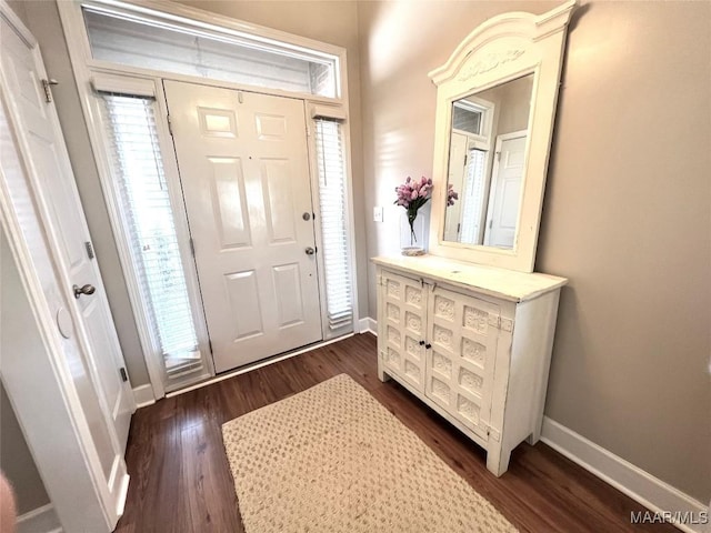 foyer entrance featuring dark wood-style floors and baseboards