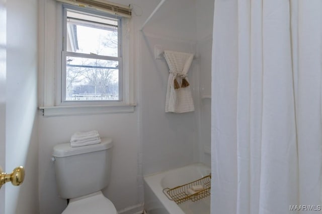 bathroom with shower / bathtub combination with curtain and toilet