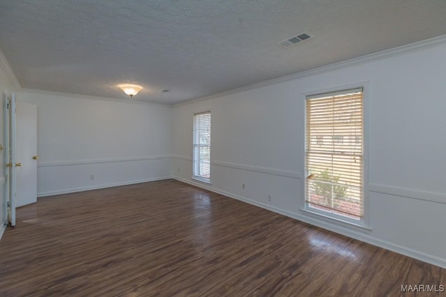 empty room with dark wood-style floors, visible vents, a textured ceiling, and ornamental molding