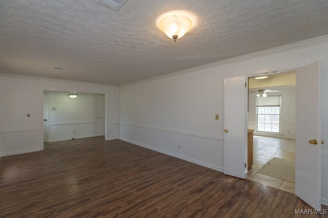 spare room featuring visible vents, crown molding, a textured ceiling, and wood finished floors