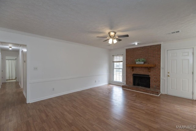 unfurnished living room with a ceiling fan, visible vents, a textured ceiling, and wood finished floors