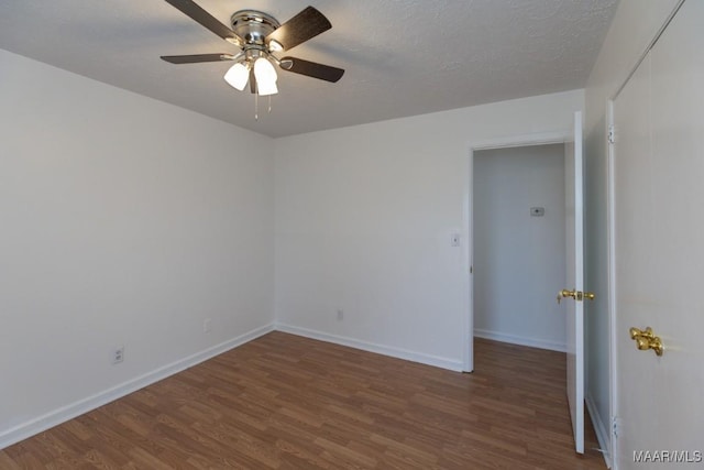 empty room featuring a textured ceiling, ceiling fan, wood finished floors, and baseboards