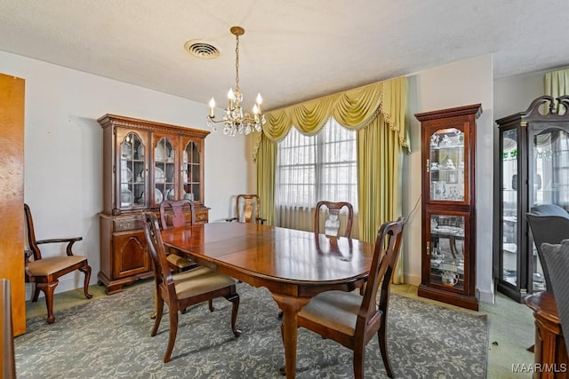 dining room with baseboards, carpet flooring, visible vents, and a notable chandelier
