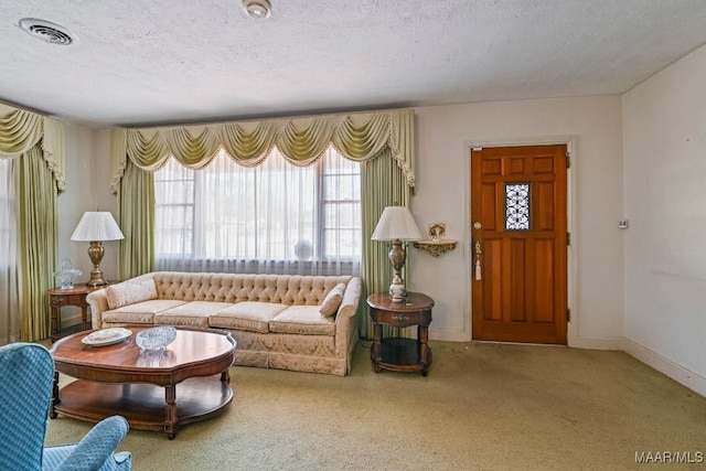 living room featuring a textured ceiling, visible vents, and baseboards