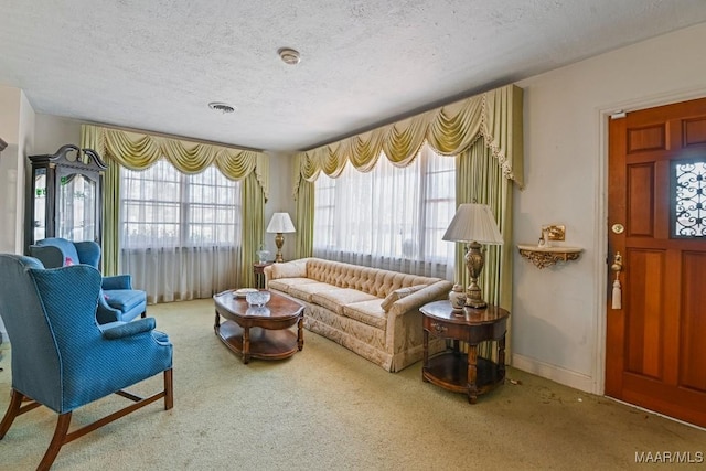 living area featuring a textured ceiling, carpet, visible vents, and baseboards