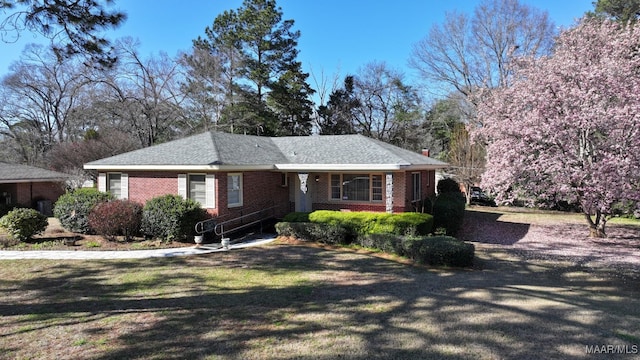 single story home featuring brick siding and a front lawn