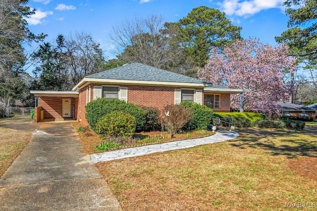 view of front of house with concrete driveway, brick siding, and a front yard