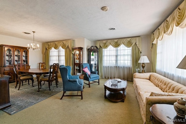 carpeted living area featuring visible vents, a chandelier, and a textured ceiling