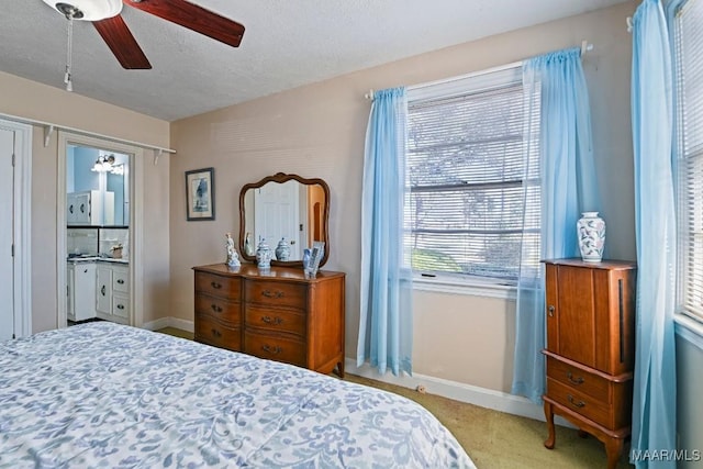 carpeted bedroom with a textured ceiling, a ceiling fan, and baseboards