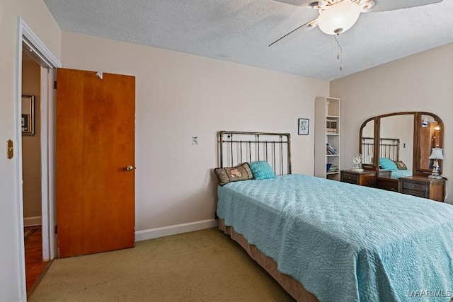 carpeted bedroom featuring a textured ceiling and baseboards