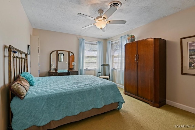 bedroom featuring ceiling fan, a textured ceiling, baseboards, and carpet flooring