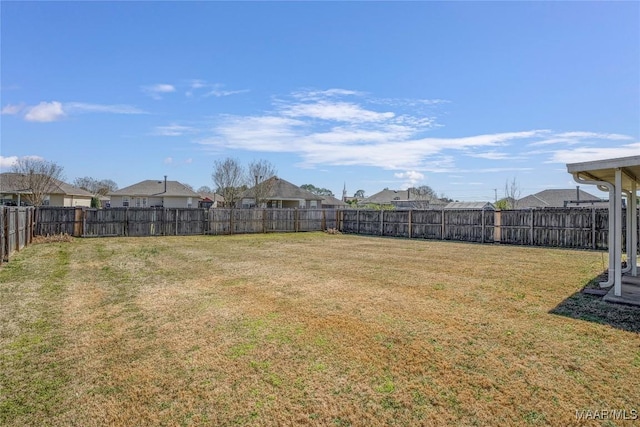 view of yard featuring a fenced backyard and a residential view