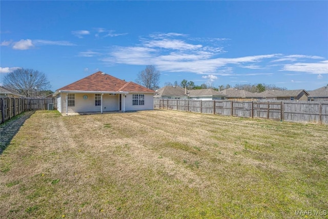 back of property with a yard and a fenced backyard