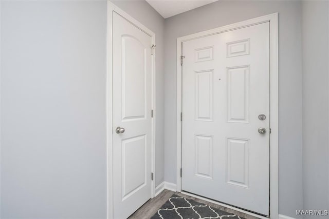 doorway to outside featuring wood finished floors and baseboards