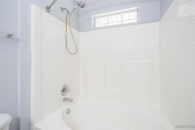 bathroom with shower / bathing tub combination and toilet