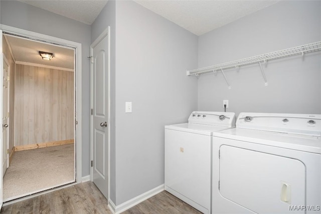 laundry room featuring light wood-type flooring, laundry area, washer and clothes dryer, and a textured ceiling