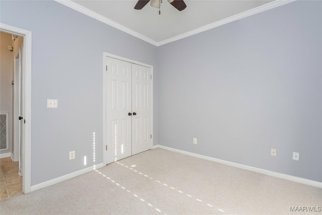 unfurnished bedroom with carpet flooring, crown molding, visible vents, and baseboards