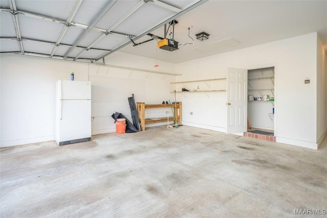 garage with baseboards, a garage door opener, and freestanding refrigerator