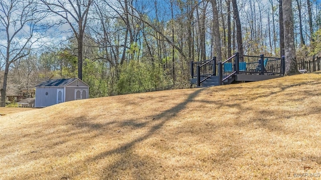 view of yard with an outbuilding, a wooden deck, and a storage shed