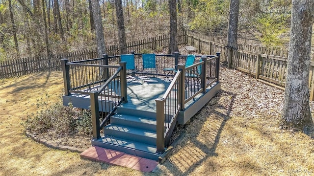 wooden terrace with a fenced backyard, stairway, and a wooded view