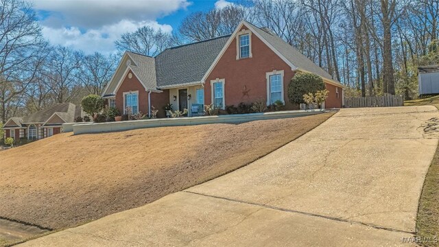 view of front of house featuring fence and brick siding