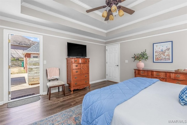 bedroom featuring baseboards, wood finished floors, access to exterior, a tray ceiling, and crown molding