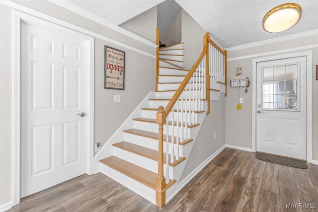 entryway featuring crown molding, a textured ceiling, baseboards, and wood finished floors