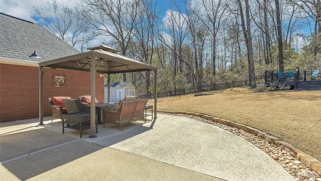 view of patio / terrace with an outbuilding, a fenced backyard, a wooden deck, and a shed