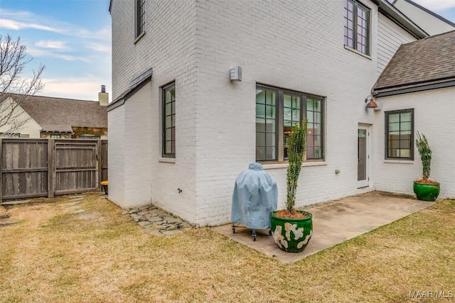 7808 Ebury St, Montgomery, AL 36116 - view of side of home with a patio, brick siding, a lawn, and fence