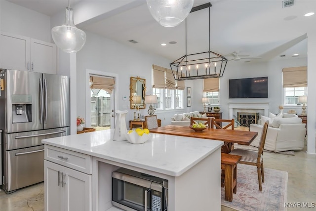 7808 Ebury St, Montgomery, AL 36116 - kitchen featuring a premium fireplace, open floor plan, a center island, stainless steel appliances, and white cabinetry
