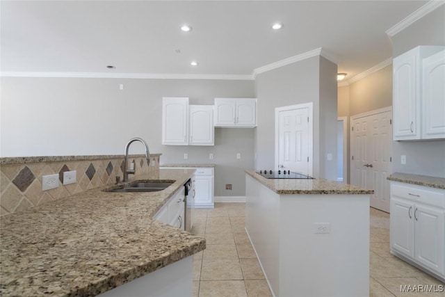 kitchen featuring light stone counters, a kitchen island, a sink, and white cabinets