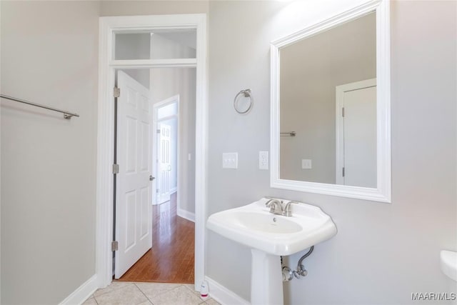 bathroom featuring tile patterned flooring, baseboards, and a sink