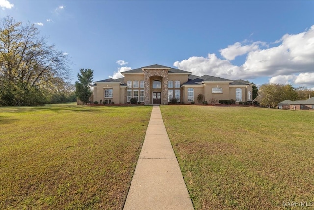 mediterranean / spanish house featuring a front lawn and stucco siding