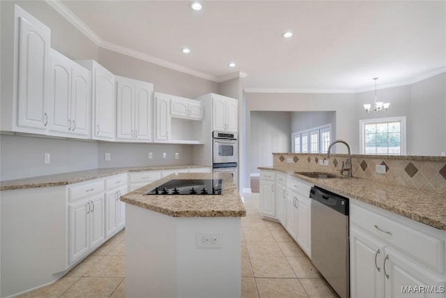 kitchen featuring stainless steel appliances, a kitchen island, a sink, white cabinetry, and decorative backsplash